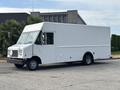A white 2018 Ford Econoline van with a boxy shape and large windshield parked with no visible branding or logos