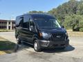 A black 2025 Ford Transit 350 van parked at an angle with a sleek design and a modern front grille