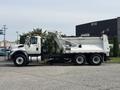 A 2013 International WorkStar dump truck with a white body and black chassis featuring a raised dump bed and various equipment mounted on the cab