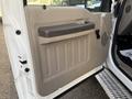 The interior door panel of a 2010 Ford F-550 showing a beige and brown design with a handle and speaker grille