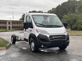 A 2023 RAM Promaster 3500 chassis cab in white with a sleek front design and visible wheels parked on a lot
