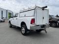 White 2015 RAM 2500 pickup truck with a utility bed and ladder rack visible in the foreground