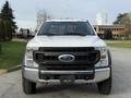 A white 2020 Ford F-550 with a large front grille and flat hood positioned directly towards the viewer, showcasing its sturdy build and rugged design