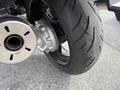 Close-up of the rear wheel and exhaust of a 2016 Yamaha FJR1300AE motorcycle showing the tire tread and silver exhaust pipe