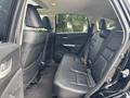 Interior view of the back seat of a 2014 Honda CR-V featuring black leather upholstery and three seats with seat belts