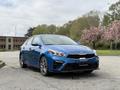 A blue 2021 Kia Forte parked with a sleek design showcasing its sporty front grille and modern headlights