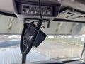 A 2009 Peterbilt Highway truck interior featuring a mounted audio system with knobs and buttons and a handheld microphone attached by a coiled cord