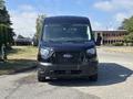 A black 2025 Ford Transit T-350 van is shown from the front with a large windshield and distinctive Ford grille design