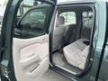 A 2004 Toyota Tacoma with an open passenger door showing a spacious interior including grey seats and a clean carpeted floor