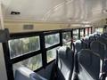 Interior view of a 2013 International CE300 school bus featuring grey seats and large windows along the left side