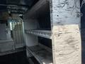 Interior of a 2005 Ford Econoline van featuring white shelves mounted on the walls for storage