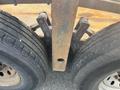 Close-up of the rear axle with two tires and a rusted metal frame connecting them