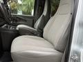 Interior view of a 2021 Chevrolet Express showing the driver and passenger seats with a light gray fabric pattern and armrests