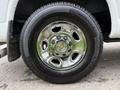 Close-up of a chrome wheel and tire from a 2004 Chevrolet Express showing the Chevrolet logo in the center and tread details on the tire
