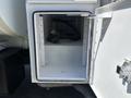 A storage compartment on a 2008 International DuraStar with an empty interior and a hose visible inside