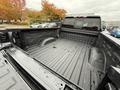 The interior of a 2022 GMC Sierra 3500HD truck bed showing a black lined surface with visible water droplets and no cargo present