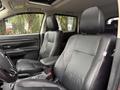 Interior view of a 2016 Mitsubishi Outlander showing black leather front seats and a center console with storage compartment and controls