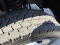 Close-up of a worn tire on a Ford F-550 showcasing significant tread wear and cracks on the rubber surface