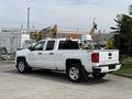 A white 2018 Chevrolet Silverado 1500 truck is shown from the rear with a crew cab and chrome details on the wheels and Chevrolet emblem