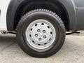A close-up of a silver wheel with a white hubcap featuring the RAM logo and a black tire labeled Agilis 200
