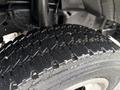 Close-up of a wet tire from a 2000 Ford F-450 showcasing a rugged tread pattern with visible water droplets on the surface