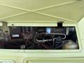The engine compartment of a 1976 GMC Motorhome showing various mechanical components wires and a coolant reservoir