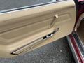 The interior door panel of a 1970 Chevrolet Corvette featuring beige upholstery a chrome handle and a smooth design
