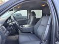 Interior view of a 2011 Chevrolet Avalanche showing two front seats and the center console with a gear shift and cup holders