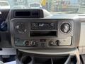 Interior dashboard of a 2021 Ford Econoline featuring a radio display and control knobs for audio settings and climate adjustments