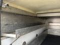 Interior view of a 2015 Ford F-450 truck bed with metal shelves and panels showing the storage area without any cargo