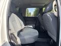 The interior of a 2013 RAM 5500 featuring a spacious rear seating area with gray cloth upholstery and seatbelts