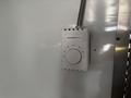 A Honeywell Home thermostat mounted on a wall with a dial for temperature control and a switch labeled OFF