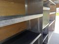 Interior of a 2016 Ford Transit van featuring multiple metal shelving units with open spaces for storage