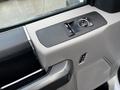 The interior control panel of a 2017 Ford F-550 featuring window controls a knob for adjusting mirrors and a textured surface