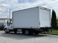 A white 2014 International TerraStar box truck with a flatbed and enclosed cargo area is parked on a lot.