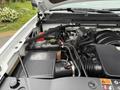 Engine compartment of a 2016 GMC Sierra 1500 featuring various components including the air intake system and fluid reservoir