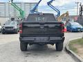 A black 2021 RAM 1500 truck viewed from the rear with dual exhausts and a distinctive RAM emblem on the tailgate