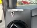A close-up of a lift gate switch labeled with a sticker indicating "LIFT GATE SWITCH" mounted on a textured panel inside a 2014 Ford F-250 SD