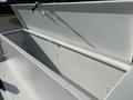 A white tool box with a hinged lid on a Freightliner M2 106 truck the box is empty and has a smooth interior surface