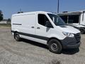 A white 2022 Mercedes-Benz Sprinter van with a gray lower section and steel wheels parked on gravel