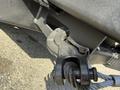 A close-up of the towing hitch assembly on a 2015 Ford F-550 showing the coupler and a steel cable attached to the mechanism