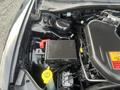 A 2015 Dodge Charger engine bay showcasing the battery and fuse box with various components and labels visible