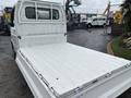 A white 2008 Suzuki Carry truck with an open rear cargo bed showcasing a flat, clean surface designed for transporting goods