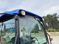 A blue and black 2009 New Holland T4020 tractor with a rounded roof and two front lights visible near the windshield
