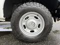 Close-up of a silver wheel with a rugged black tire on a 2015 Ford F-350 SD showing the detailed tread pattern and alloy rim design