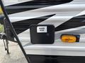 A 2021 Jayco Jay Flight with a compartment labeled sewer hose and an amber clearance light