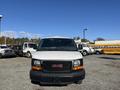 A 2016 GMC Savana van front view with a white body and black grille showcasing the GMC logo in red