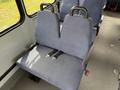A pair of gray upholstered seats with seatbelts inside a vehicle
