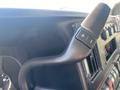 Close-up of the gear shift lever of a 2011 Chevrolet Express with buttons for gear shifting and a sleek black design