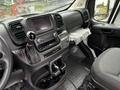 Interior view of a 2023 RAM Promaster 3500 showing the dashboard with a touch screen display a gear shift and seating area